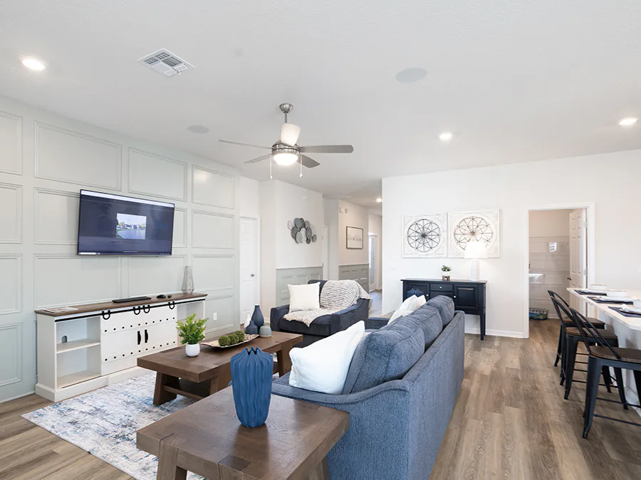 Living area decorated with creamy whites and calming green and blue tones, accented by natural wood